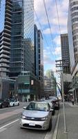 Vancouver Canada 2023 metropolis groot stad leven wolkenkrabbers hoog nieuw modern en oud huizen kantoor stad stormloop uur verkeer Vancouver architectuur timelapse laag hoek visie van wolkenkrabbers video