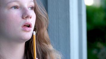 Nahansicht Gesicht von Teenager Mädchen nehmen Bleistift im Mund zu denken Denken auf Straße Mädchen jung Frau zeichnet schreibt tut Hausaufgaben Jugend denken Traum Fräulein video