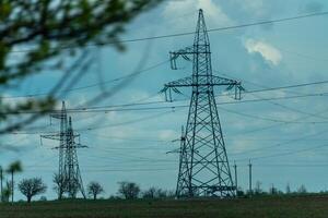 High voltage towers with sky background. Power line support with wires for electricity transmission. High voltage grid tower with wire cable at distribution station. Energy industry, energy saving photo