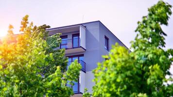 Modern residential building with new apartments in a green residential area. Eco architecture. Green tree and new apartment building. The harmony of nature and modernity. photo