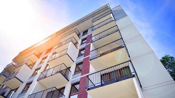 A view at a detail of a modern white apartment building with blue sky background. photo