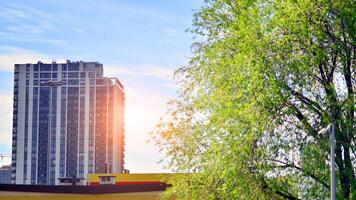 Modern residential building with new apartments in a green residential area. Eco architecture. Green tree and new apartment building. The harmony of nature and modernity. photo