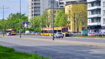 Warsaw, Poland. 28 April 2024. Modern red and yellow trams on street. Public transport. photo