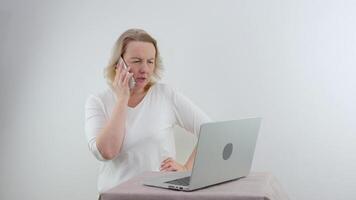 Frustrated woman having problem with not working smart phone sitting at home office desk, indignant confused businesswoman annoyed with discharged or broken cell, received bad news in mobile message video