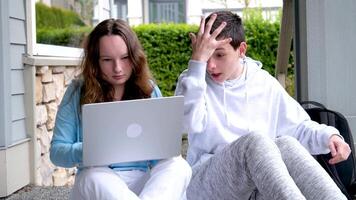 Garoto detém garganta menina fecha boca olhando às computador portátil apontando com dedo este isto é não Claro quão para resolver problema rindo tendo Diversão adolescentes Internet social redes conectados Aprendendo lições video