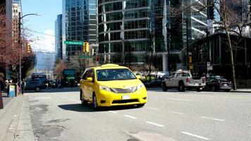 Jaune Taxi voiture qui passe sur le route près le caméra lent mouvement Vancouver ville Canada désert des rues travail journée tout dans Bureau bâtiments video