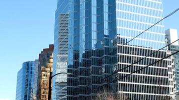 mooi glas gebouwen wolkenkrabbers stijgende lijn in de blauw lucht zonder wolken Vancouver kers bloesems in voorjaar de camera langzaam vangt de stadsgezicht kantoor gebouwen de laatste technologie video