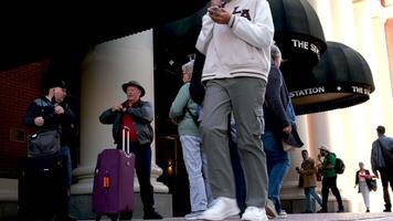 Reisende mit Koffer im Hüte mit Rucksäcke Stand in der Nähe von Himmel Zug Bahnhof entscheiden welche Weg zu gehen nehmen aus Masken aussehen links und richtig Fragen Passanten echt Menschen echt Leben im das groß Stadt von Vancouver video