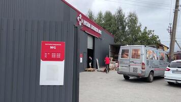 nieuw mail bagage gedeelte levering van groot pakketten dozen laden in de auto kwestie bagage levering Mens in een rood t-shirt uniform trolley levering Oekraïne vinnitsa video