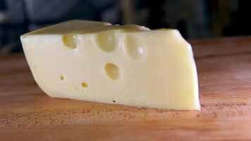 fêmea mãos corte queijo com uma faca em uma de madeira corte borda. video