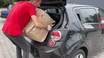 Neu Mail Gepäck Abteil Lieferung von groß Pakete Kisten Belastung in das Auto Problem Gepäck Lieferung Mann im ein rot T-Shirt Uniform Wagen Lieferung Ukraine Winniza video