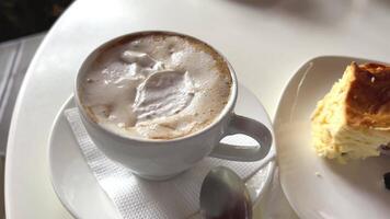 proche en haut image de petit pièces de une pêche tarte, lutin, biscuit, et une cheesecake sur une petit porcelaine plaque. une brillant fourchette est suivant à assiette et tout sont servi avec une tasse de Lait café dans une tasse. video