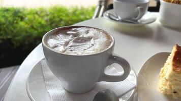 proche en haut image de petit pièces de une pêche tarte, lutin, biscuit, et une cheesecake sur une petit porcelaine plaque. une brillant fourchette est suivant à assiette et tout sont servi avec une tasse de Lait café dans une tasse. video