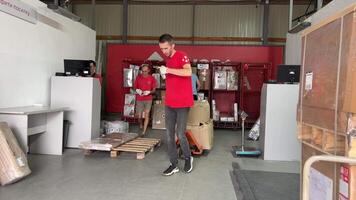 nieuw mail bagage gedeelte levering van groot pakketten dozen laden in de auto kwestie bagage levering Mens in een rood t-shirt uniform trolley levering Oekraïne vinnitsa video