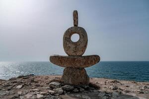 escultura símbolo hecho de grande guijarros en contra el azul cielo foto