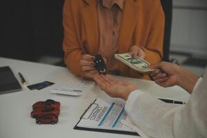 Insurance officers hand over the car keys after the tenant. have signed an auto insurance document or a lease or agreement document Buying or selling a new or used car with a car photo