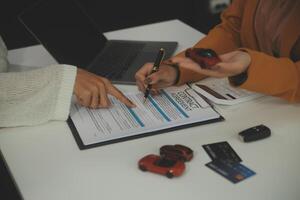 Insurance officers hand over the car keys after the tenant. have signed an auto insurance document or a lease or agreement document Buying or selling a new or used car with a car photo