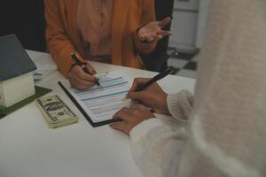 Discussion with a real estate agent, House model with agent and customer discussing for the contract to buy, get insurance or loan real estate or property. photo