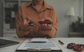 Insurance officers hand over the car keys after the tenant. have signed an auto insurance document or a lease or agreement document Buying or selling a new or used car with a car photo