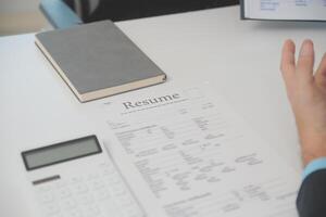 cerca arriba ver de trabajo entrevista en oficina, atención en currículum escritura consejos, empleador revisando bueno CV de preparado experto solicitante, reclutador considerando solicitud, hora gerente haciendo contratación decisión foto