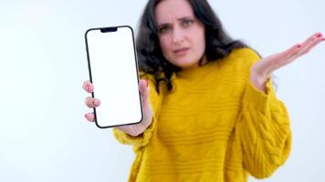 Close-up chromakey smartphone in hand of dissatisfied young woman shaking head. Portrait of unsatisfied Caucasian millennial lady posing with green screen phone. Social media web page mockup video