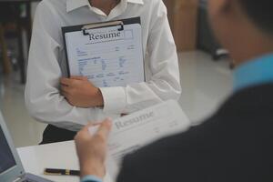 cerca arriba ver de trabajo entrevista en oficina, atención en currículum escritura consejos, empleador revisando bueno CV de preparado experto solicitante, reclutador considerando solicitud, hora gerente haciendo contratación decisión foto