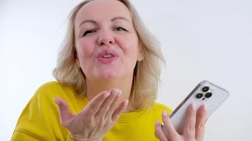 tusenåriga social media bloggare vinka och sändning luft kyss till kamera på smartphone. göra selfie för blog eller minnen. generation z ny begrepp studio. ung kvinna med rosa hår på pastell bakgrund video