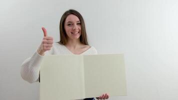 vide espace pour texte dans le mains de le fille album bloc-notes blanc pages fille montrant les pouces en haut La publicité pratique utile être santé video