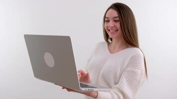 giovane adulto attività commerciale donna digitando su il computer portatile computer Lavorando nel Internet, bellissimo femmina professionale utente signora utilizzando pc tecnologia fare in linea lavoro nel ufficio o navigazione ragnatela sedersi a casa tavolo video