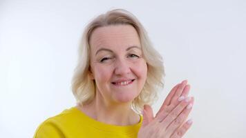 beautiful woman applauds laughing smiling clapping her hands on the right on the left laughing on a white background blinking her eye biting her lower lip video