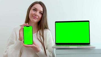 girl scratches her chin straightens her hair smiles looks into the frame chroma key green monitor screen advertising space for text studio white background long hair well-groomed beauty video