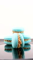A girl lays out blue and pink macaroons to take a photo on grey background. Macaroons on grey background, colorful french cookies macaroons. Creative layout made of colorful macaroons. Food concept. video