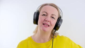 Happy Girl using Headphones, starting to dance while Listening to Music. Beautiful Girl dancing on Studio in big Headphones, having Fun. Music Applications. Good Music. Music Lovers. video