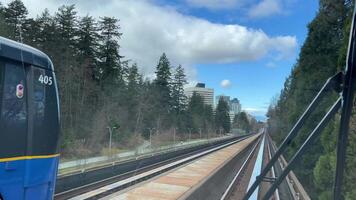 sky train road from Surrey to Vancouver passing trains skyscrapers office buildings science center and other stations from King George to Waterfront real life in a big city british columbia 2023 video