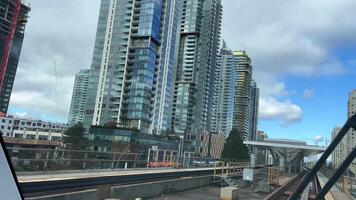 tournage de le de face fenêtre de le train aérien, il passe en dessous de des ponts, vous pouvez voir le voitures de le bâtiment et le tout chemin de fer tournage lent mouvement non gens nulle part surrey Vancouver Canada video