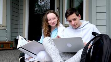 nett zu tun Hausaufgaben zusammen mit ein Freund Jungs Mädchen Sitzung auf das Veranda Laptop Aktentasche Mappe draußen Zuhause Turnschuhe Sportbekleidung angenehm Beziehung zuerst Liebe Klassenkameraden Jugendliche Jugend video