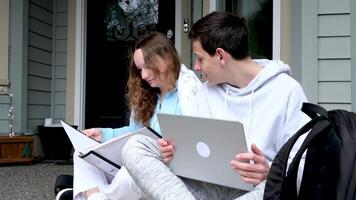 Aufforderung Lösung von Problem Junge und Mädchen Sitzung auf Straße tun Schule Zuordnungen Portfolio Notizbuch Mappe mit Blätter Bleistift zwei Tassen von Tee Kaffee angenehm Beziehung Teenager Junge video