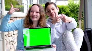 populair koel foto van tieners Holding laptop groen rand chroma sleutel ze tonen vingers advertentie online aan het leren tiener- leven gelukkig einde pret vermaak spellen internet sociaal netwerken mooi reclame video