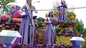 cloverdale nyack festival kmck skön kvinnor i lila klänningar med en krona och skönhet drottningar är körning en bil längs de gata av en Gay parad vinka deras händer med band leende applåderar video
