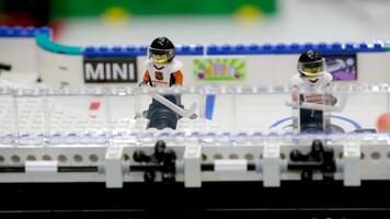 hockey game two hockey players Lego toys from the constructor hit the balls spinning in one place beautiful recreation interesting structure game for children and adults building at the exhibition video