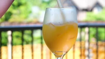 Bebiendo naranja jugo con hielo de cerca vaso Paja tracción mediante un Paja frío bebida emocionante hielo cubitos enfriamiento verano Bebiendo en el calor video