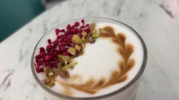 heiß Latte mit Schaum. Latté mit Nüsse und getrocknet Beeren Pistazien und Preiselbeeren video