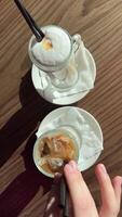 el camarero sirve dos lattes, caliente y frío, comparando el dos sabores hielo latté y caliente tarde video