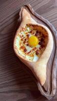 person mixing suluguni cheese and egg yolk in georgian adjarian khachapuri Georgian cheese pastry khachapuri with egg served on wooden board video