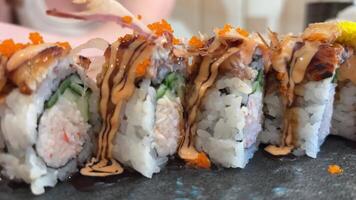 BLACK DRAGON ROLL Crabmeat, Avocado, Kappa Inside with Unagi, Avocado, Fish Flakes and Fish slow motion from the side video