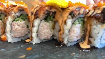 BLACK DRAGON ROLL Crabmeat, Avocado, Kappa Inside with Unagi, Avocado, Fish Flakes and Fish slow motion from the side video