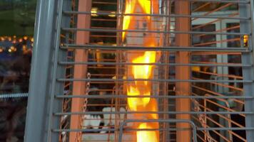 interesting bewitching background fire burning in a flask behind bars with chains against the backdrop of a restaurant place for advertising text attracting attention Eternal flame bask warmly when video