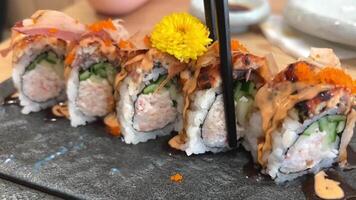 negro continuar rodar carne de cangrejo, palta, kappa dentro con unagi, palta, pescado copos y pescado tomar un pedazo de Sushi rodar con negro palillos video