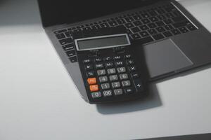 Flat lay, top view office table desk. Workspace with calculator,pen,laptop on white background.Copy Space for text,Empty Blank to word.Business Finance,Education Technology.Work from home. photo