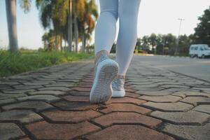 Young fitness woman runner stretching legs before run on city photo